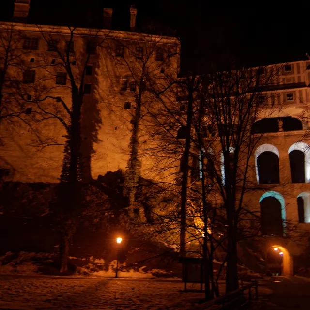 Český Krumlov Castle lit at night above the river