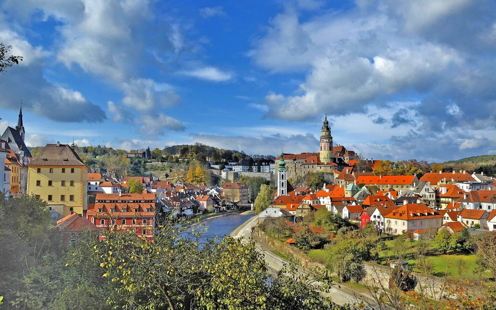 The painted Renaissance tower of Český Krumlov Castle above the red roofs of the old town